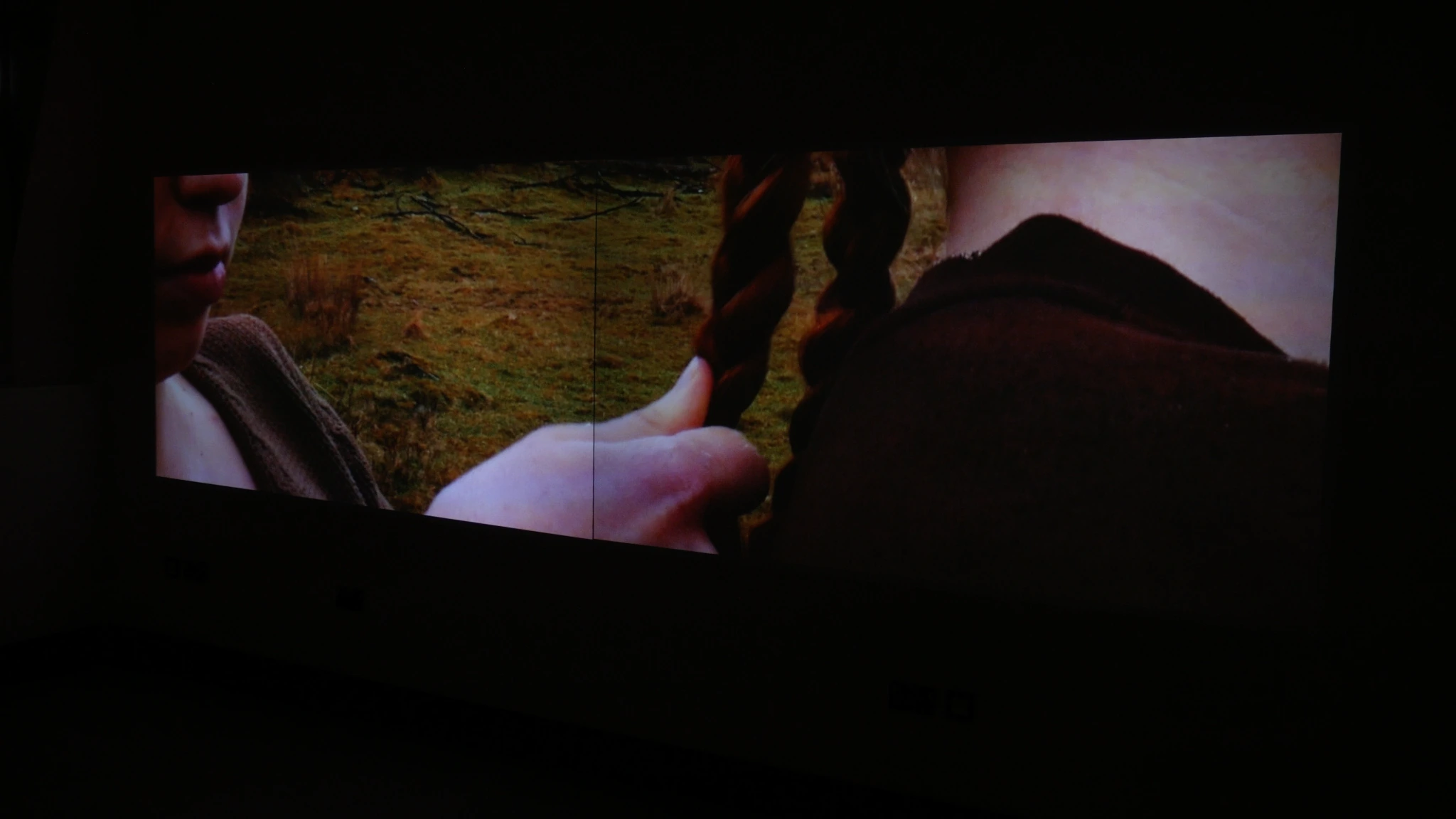 Moving images projected across a dark gallery wall